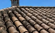 Terracotta roof covered in dark algae before cleaning
